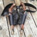 Black leather dual flintlock shoulder holster shown in flat lay on wooden surface