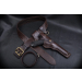 complete set displayed with matching belt, leg strap, and handgun on black leather surface