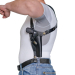 Black leather shoulder holster worn under clothing with revolver in vertical carry position
