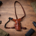 Hybrid Leather Chest Rig Holster laid flat on a wooden surface showing brown leather holster body and adjustable harness