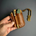 Brown leather EDC pocket organizer held in hand with knife, pen, flashlight, and prybar inserted.