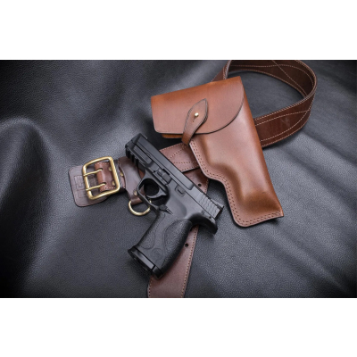 displayed with matching leather belt and handgun on black leather surface