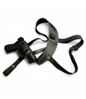 Black leather shoulder holster with adjustable straps and reinforced stitching, laid flat on white background