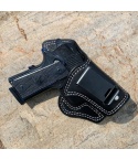 Black leather IWB holster with 10 degree cant and metal belt clip on stone surface