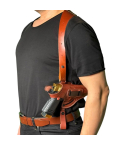 Brown leather shoulder holster worn under the arm with horizontal carry over black t-shirt