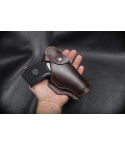 Brown Leather Field Guard Holster held in hand with pistol inserted showing covered front and snap strap
