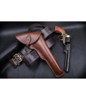 displayed with matching leather belt and long barrel revolver on black leather surface