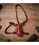 Hybrid Leather Chest Rig Holster laid flat on a wooden surface showing brown leather holster body and adjustable harness