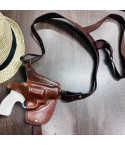 Mahogany leather horizontal shoulder holster with harness displayed on tabletop
