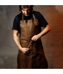 Personalized leather utility work apron worn by model adjusting waist straps