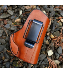 Brown Leather IWB Holster With Clip detail image showing molded leather body and stitched edge on outdoor ground