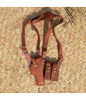 Leather shoulder holster rig with adjustable straps and dual magazine pouches laid flat on woven surface